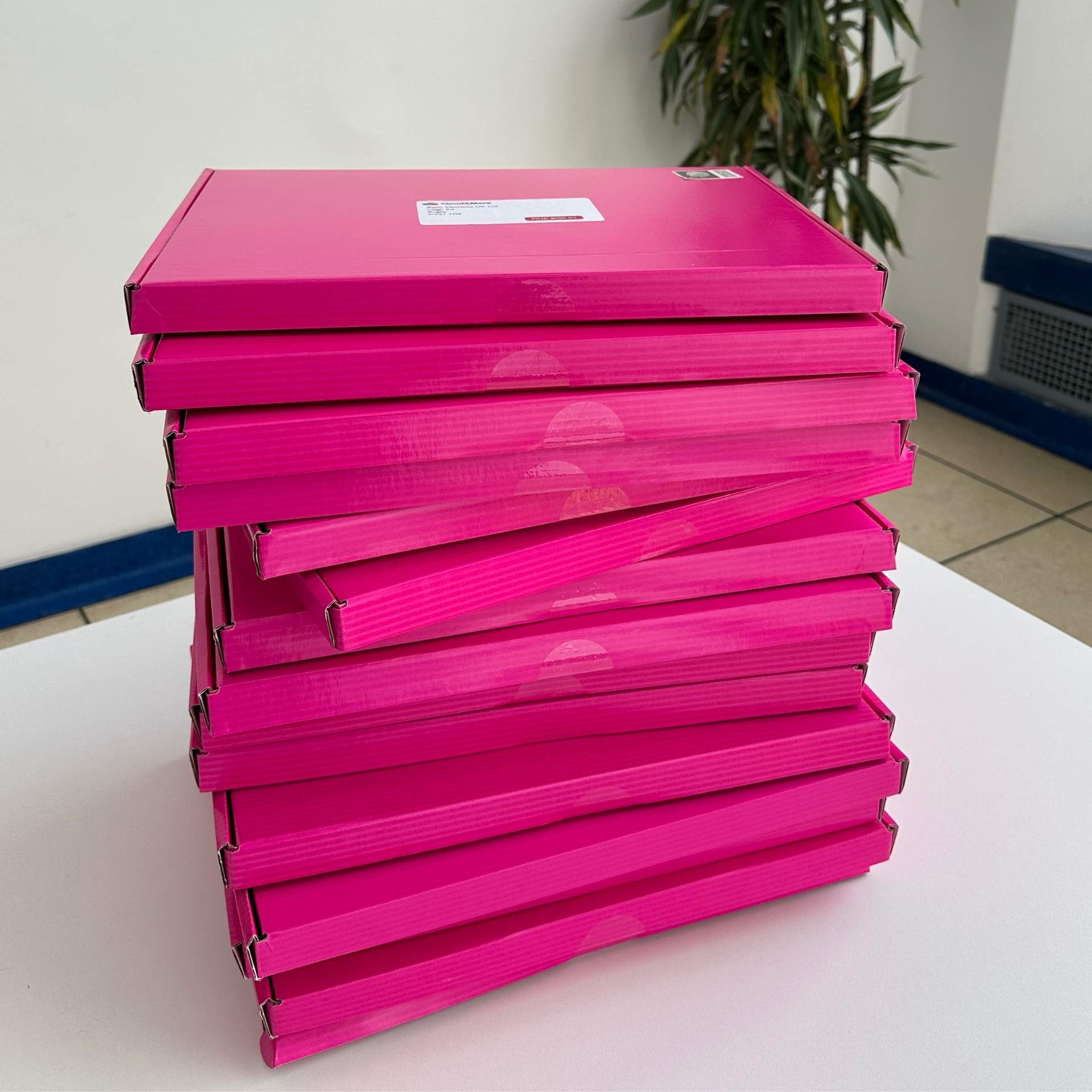 A stack of the pink Cloud & More boxes we send to businesses we’d love to help